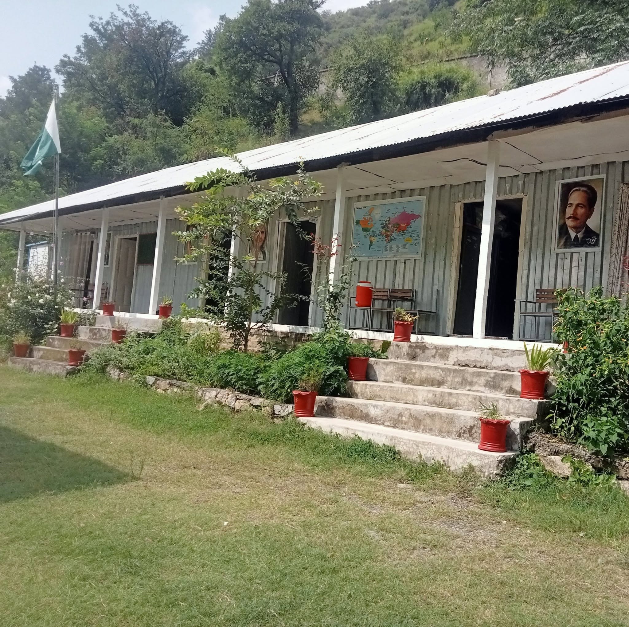 GHS Kotgali school building with a green courtyard and Pakistan flag